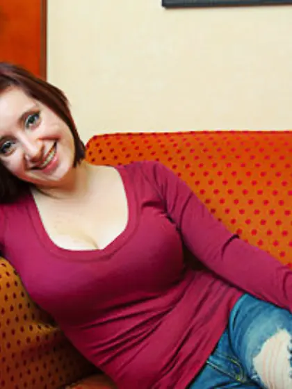 Playful red-haired mom poses topless to reveal her natural melon