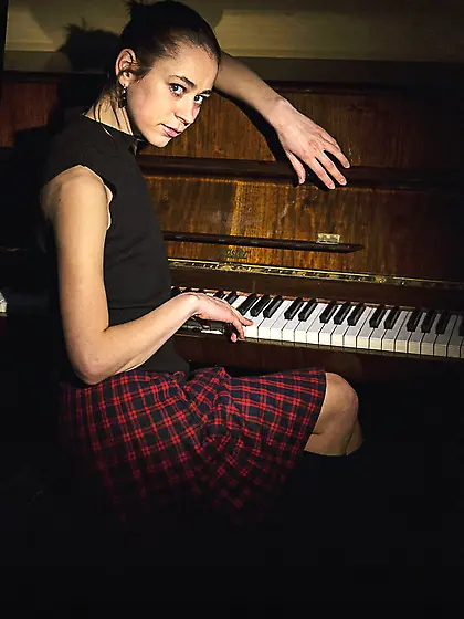 Girl shows off her body after a piano session.