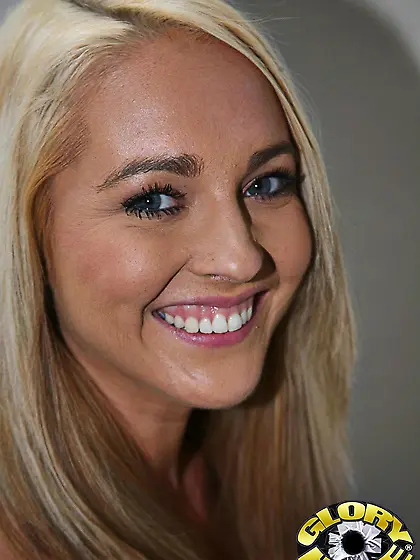 Pretty blonde Ashley Stone is smiling into camera and showing mo