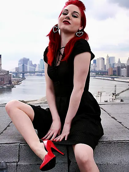 Tempting teen with red hair and high heels takes her black dress