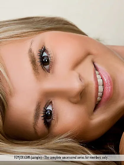 The hot blonde teen Audri Nubiles posing in the bedroom in black