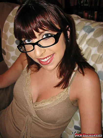 Nerdy brunette sucks a big shaft on the couch.