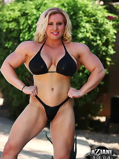 Muscled blonde woman shows off in a black...
