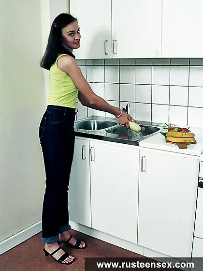 Teen brunette masturbates in the kitchen