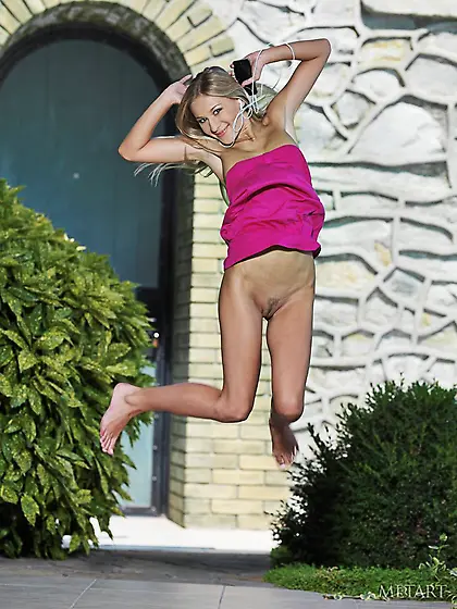 Blonde lady shows her big breasts and long legs while posing on