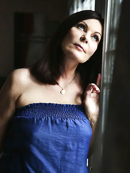 Black-haired mature strips near window while waiting for arrival