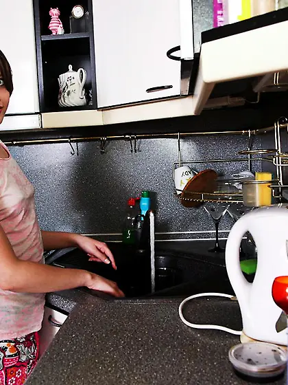 Leggy brunette teen Juliette D plays in the kitchen where she sa