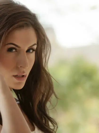 Dark-haired seductress in white masturbating on a red couch here