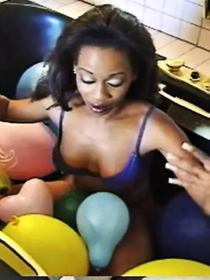 Black gal plays with balloons in the jacuzzi